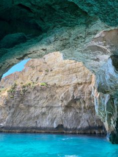 the inside of an ocean cave with blue water