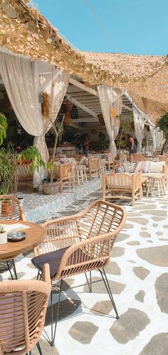 an outdoor dining area with tables and chairs, covered in white draping on the ground