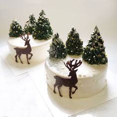 two cakes decorated with christmas trees and deer