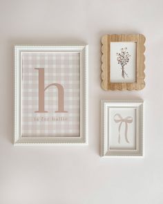 three framed pictures hang on the wall next to each other, one with a monogrammed letter