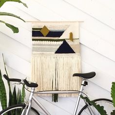 a bicycle parked next to a wall hanging