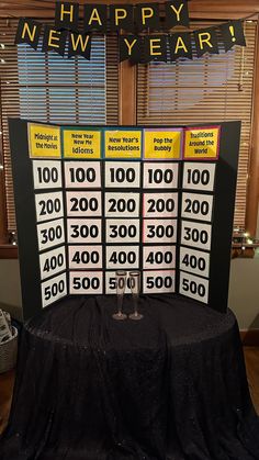 a table topped with a black cloth covered tablecloth next to a sign that says happy new year