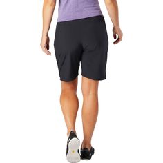 the back view of a woman wearing black shorts and a purple shirt, with her hands on her hips