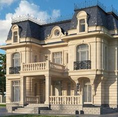 a large beige building with two balconies on the second floor and a balcony