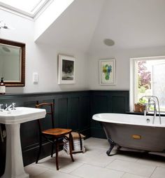 a bathroom with a claw foot bathtub and pedestal sink in the center, along with two stools on either side of the tub