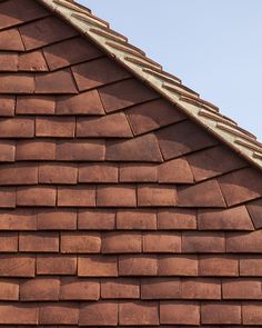 a close up view of a red brick building with a bird perched on the roof