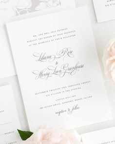 the wedding stationery is laid out on top of each other, with pink flowers