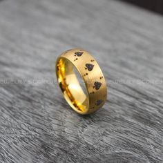 a gold wedding ring with black triangles on the inside and inlays to it