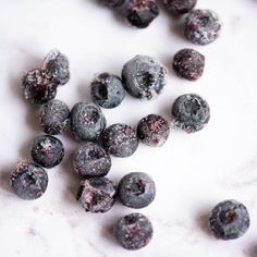 blueberries are scattered around on a white surface