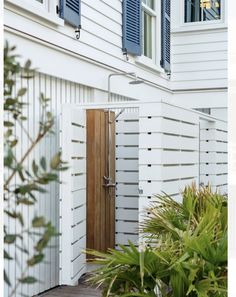 a white house with blue shutters and a wooden door