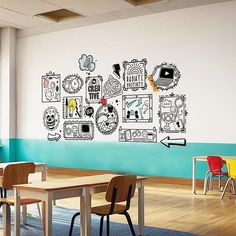 a classroom with desks and chairs in front of a wall painted with cartoon drawings