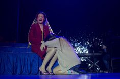 two women on stage with one holding the other's head