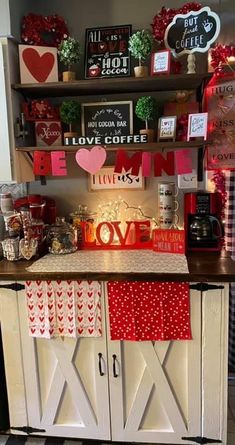 a kitchen with red and white decor on the cabinets, shelves and decorations above it