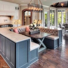 a large open concept kitchen and dining room with an island in front of the window