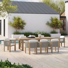 an outdoor dining table with white chairs around it