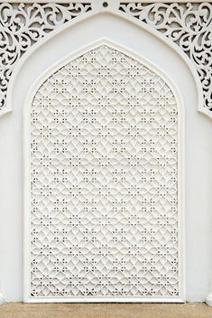 an intricate white wall with carvings on it