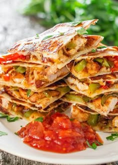 several quesadillas stacked on top of each other with tomatoes and green peppers