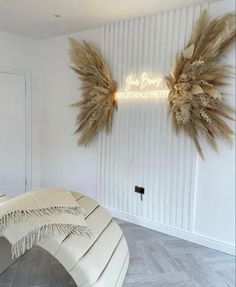 a room with white walls and two large dried wheat wreaths on the wall