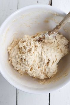 a white bowl filled with batter on top of a wooden table