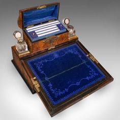 an antique wooden box with blue velvet lining and two glass knobs on the lid