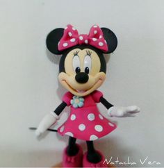 a minnie mouse figurine is posed on a table