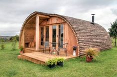 a small wooden cabin sitting on top of a lush green field