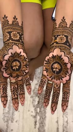 two hands with henna designs on them