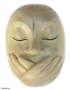 a wooden mask with two hands covering it's face and the eyes are closed