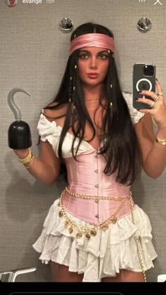 a woman in a pink corset and headband is holding an umbrella while taking a selfie