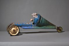 an old metal toy car with wheels that has been painted blue and rusted gold