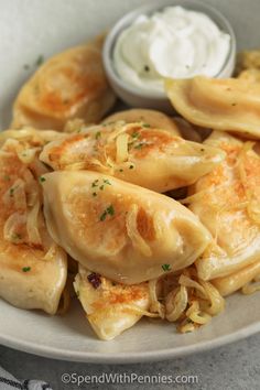 a white plate topped with dumplings covered in cheese