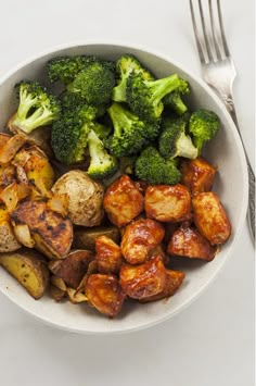 a bowl filled with potatoes and broccoli on top of a white tablecloth