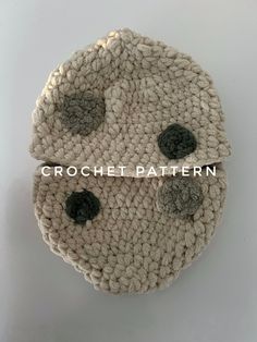 two crocheted coasters sitting on top of each other with black and white buttons