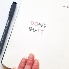 a person's hand on top of a notebook with the words don't quit written in it