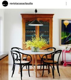 a dining room table with four chairs and a potted plant on top of it