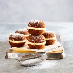 some sugar covered donuts are on a plate with a fork and spoon next to them