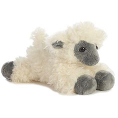 a white and grey stuffed sheep laying down