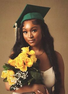 a woman wearing a graduation cap and gown with flowers in front of her face, holding a bouquet of yellow roses