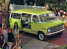 a group of people standing in front of a green van