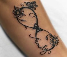 a tattoo on the leg of a woman with flowers and butterflies around her ankles,