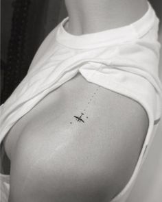 a woman with a small airplane tattoo on her left side ribcading the back of her body