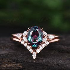 an engagement ring with a blue topazte surrounded by white diamonds on a piece of wood