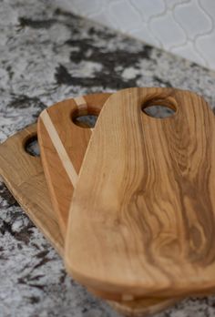 three wooden cutting boards sitting on top of a counter