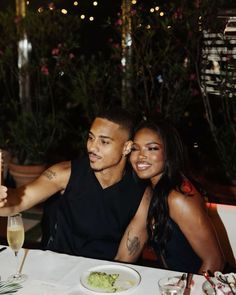 a man and woman sitting at a dinner table