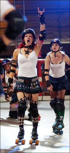 two women on roller skates with one holding her hand up and the other pointing