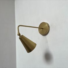 a brass wall light on a white wall