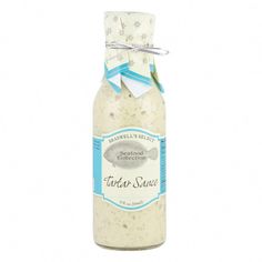 a bottle of white sauce with a blue ribbon around it's neck on a white background