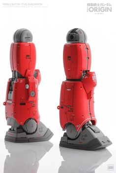 a red robot is standing on top of a black base