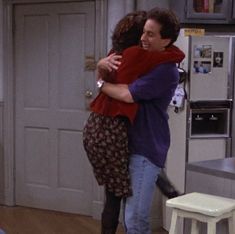 a man and woman hug in the kitchen