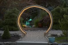 night outdoor setting with a wood arch with white lights on it, a gravel path and  trees Waterfall Sounds, Evening View